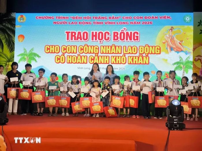 Tặng học bổng cho con công nhân lao động có hoàn cảnh khó khăn. (Ảnh: Huỳnh Phúc Hậu/TTXVN)