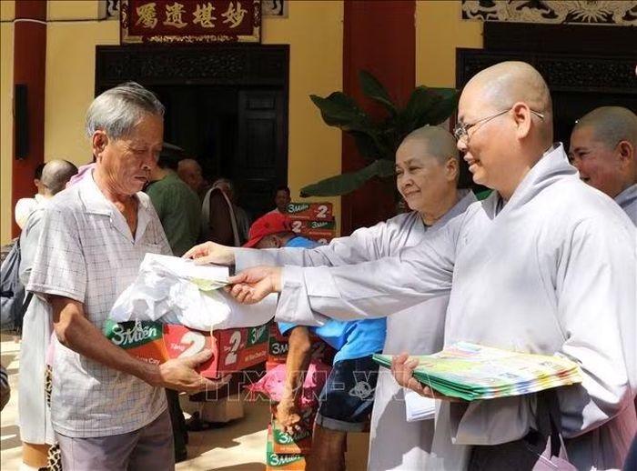 Chư ni hỗ trợ lực lượng công an Đồng Tháp phát tờ rơi tuyên truyền phòng, chống tội phạm cho bà con nhân dân.