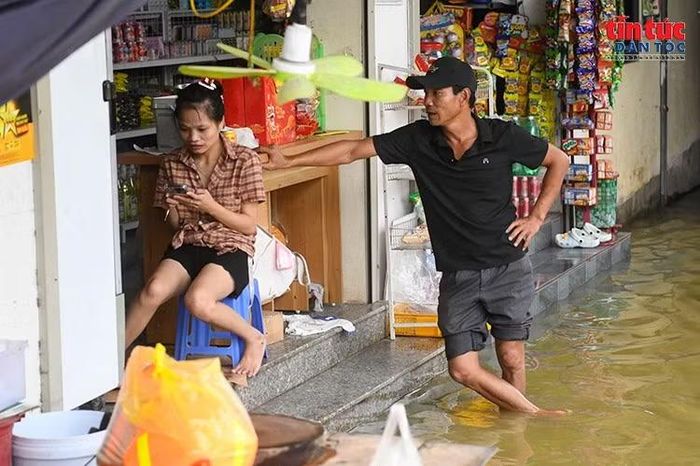 Nước ngập tới bậc cửa, ảnh hưởng trực tiếp đến hoạt động buôn bán và sinh hoạt của người dân.