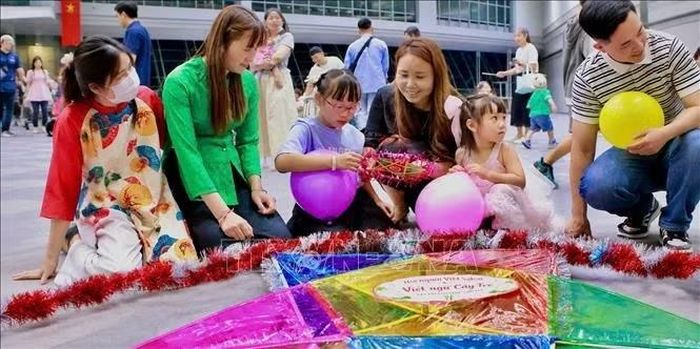 Các em nhỏ được hướng dẫn trang trí cho đèn ông sao tại chương trình vui Tết Trung thu tại Sakai, Osaka.