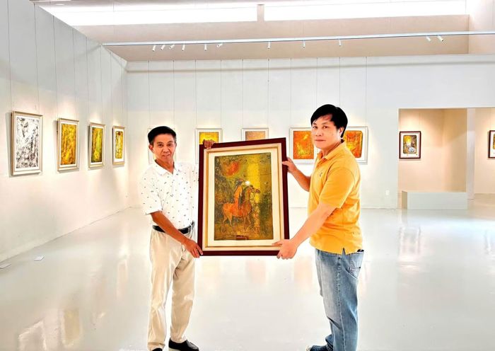 Nhà sưu tập Trần Thắng (trái) bên tác phẩm về hình tượng ngựa của cố hoạ sĩ Lê Bá Đảng.