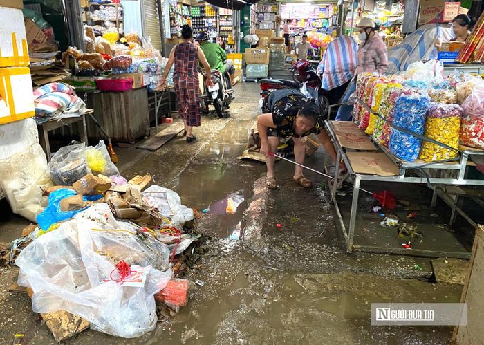 Các tiểu thương đã thu gom và tập kết rác thải, bùn đất thành từng đống gọn gàng để các công nhân môi trường có thể dễ dàng bốc xúc, xử lý và vận chuyển đi nơi khác.