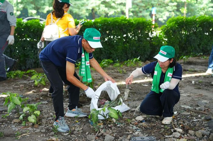 Các tình nguyện viên thu dọn rác tại khu vực đường Phạm Hùng, phường Từ Liêm.