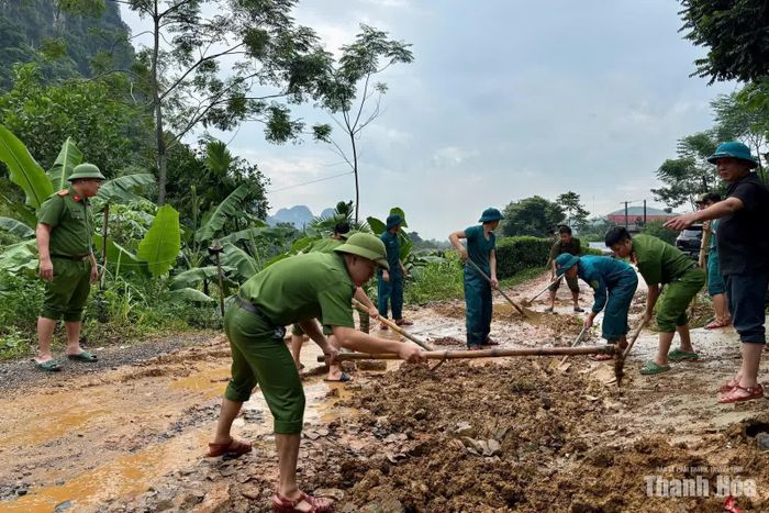 Các lực lượng xã Ngọc Lặc thu dọn bùn đất trên các tuyến đường vào khu dân cư sau khi nước rút.