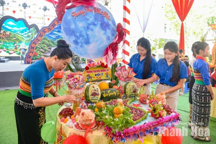 Người giữ nhành hoa, người đính chùm quả; sự ăn ý và ánh mắt động viên tạo nên nhịp điệu thi đua khẩn trương tràn ngập tiếng cười gắn kết.