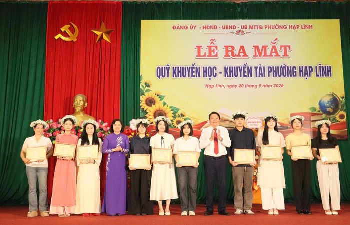 Đồng chí Trần Thị Hằng và lãnh đạo phường Hạp Lĩnh khen thưởng các sinh viên tốt nghiệp xuất sắc.