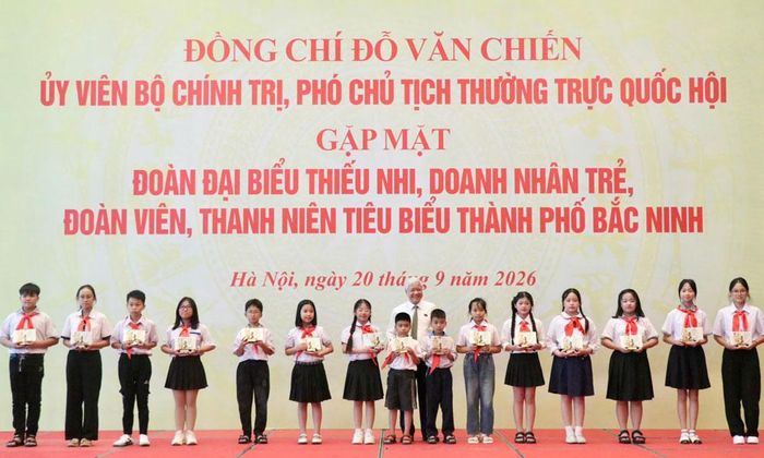 Đồng chí Đỗ Văn Chiến tặng quà lưu niệm cho các em học sinh học giỏi.