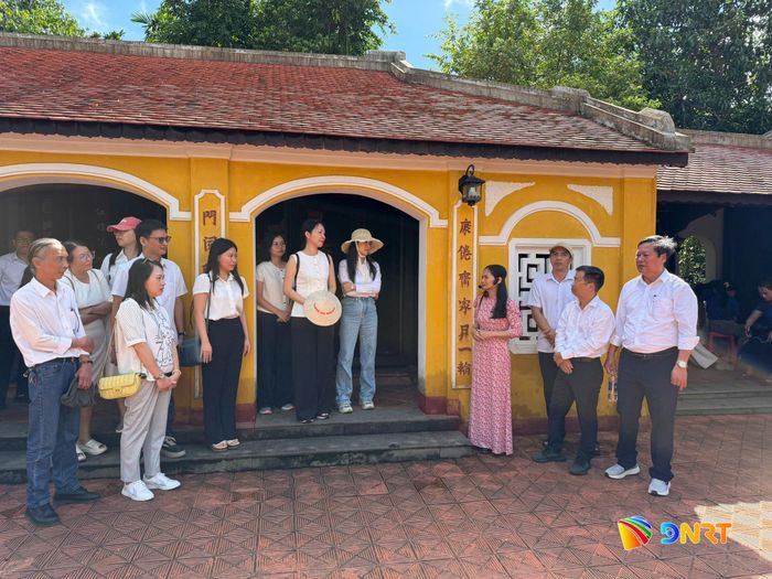 Chị Nguyễn Thị Minh Toán (áo dài hồng) thuyết minh cho đoàn về cuộc đời của cụ Huỳnh. Ảnh: PHƯƠNG MINH