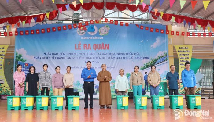 Ban tổ chức trao thùng rác cho các hộ dân. Ảnh: Ngọc Huyền