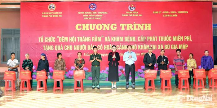 Dịp này, thủ trưởng Bộ Chỉ huy Quân sự thành phố và các đơn vị phối hợp, các nhà tài trợ trao tặng nhiều phần quà cho các hộ dân khó khăn xã Bù Gia Mập. Ảnh: Minh Tiến