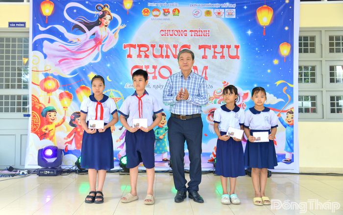 Đồng chí Nguyễn Minh Tâm, Phó Bí thư Thường trực Đảng ủy xã Long Định, trao các suất học bổng cho học sinh có hoàn cảnh khó khăn.