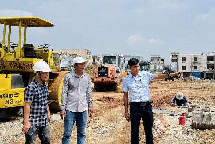 Cán bộ Ban Quản lý phường Bình Định kiểm tra tiến độ thi công công trình chỉnh trang đô thị trên địa bàn. Ảnh: N.H