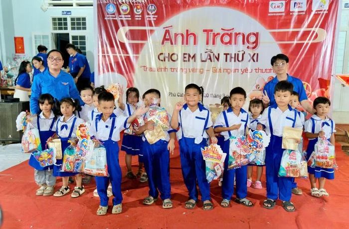 Đại diện Câu lạc bộ tình nguyện Những người bạn và Đoàn xã Phù Cát tặng quà cho thiếu nhi Trường Tiểu học số 2 Phù Cát phân hiệu 2. Ảnh: M.N