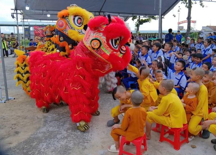 Các em thiếu nhi ở Trường Tiểu học số 2 Phù Cát phân hiệu 2 và thiếu nhi chùa Mỹ Hóa hào hứng xem múa lân. Ảnh: M.N