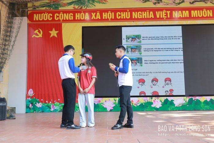 Nhân viên Công ty Honda Lộc Bình hướng dẫn học sinh đội mũ bảo hiểm đúng quy cách