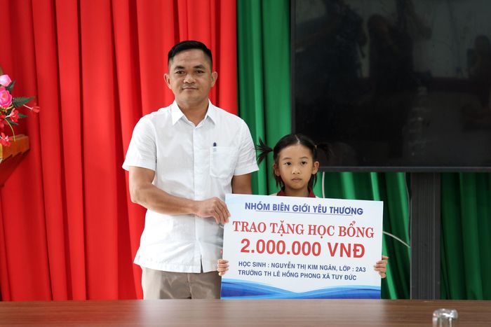 Ông Điểu Hùng, Phó Bí thư Thường trực Đảng ủy xã Tuy Đức trao học bổng tới cháu Nguyễn Thị Kim Ngân