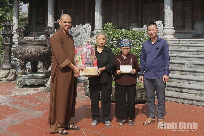 Đại đức Thích Thanh Toàn (ngoài cùng bên trái), chùa Vạn Điểm (tên thật là Trần Văn Hùng) là đảng viên sinh hoạt tại Chi bộ 3, Đảng bộ xã Ý Yên tặng quà cho các gia đình có hoàn cảnh khó khăn tại địa phương. Ảnh: Việt Thắng