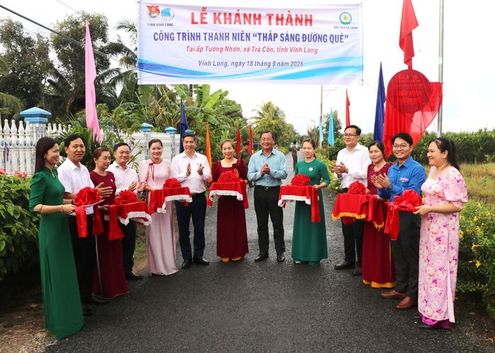 Đại diện Học viện Tài chính và các đơn vị thực hiện nghi thức cắt băng khánh thành công trình thanh niên “Thắp sáng đường quê” tại xã Trà Côn. Ảnh: Ngọc Bích