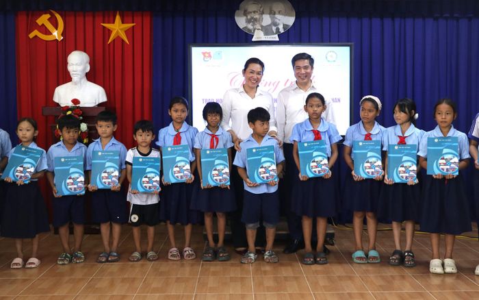 NGƯT. PGS.TS Nguyễn Đào Tùng, Giám đốc Học viện Tài chính và Bí thư Đảng ủy xã Vĩnh Xuân Đặng Thị Bé Sáu trao học bổng cho các em học sinh có hoàn cảnh khó khăn trên địa bàn xã. Ảnh: Ngọc Bích