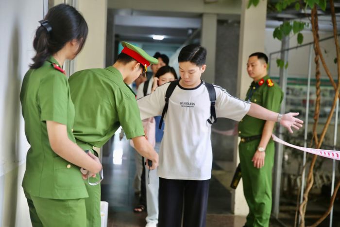 Cán bộ coi thi kiểm tra thí sinh trước khi vào phòng thi tại Học viện Cảnh sát nhân dân.