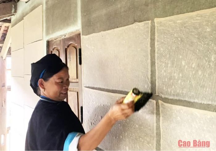 Chị Nông Thị Kính, xóm Dìa Trên, xã Quảng Uyên thực hiện quy trình phơi giấy bản trên tường nhà.