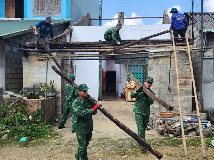 Đoàn viên, thanh niên Đồn Biên phòng Đàm Thủy giúp gia đình chị Hoàng Thị Điệp, xóm Bồng Sơn, tháo dỡ mái nhà cũ để lợp lại mái tôn mới.
