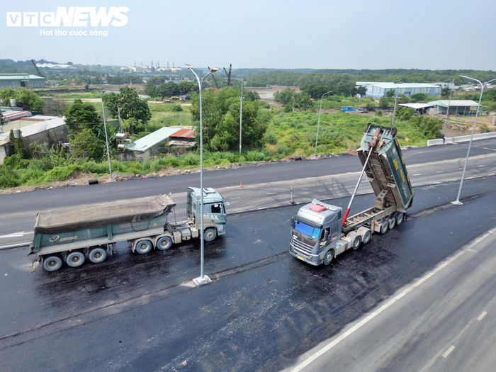 Máy móc liên tục hoạt động tại các vị trí còn thi công. Công nhân thực hiện những phần việc hoàn thiện mặt đường, lắp đặt hệ thống đảm bảo an toàn giao thông.