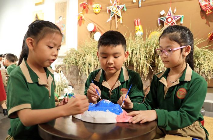 Được tham gia làm đồ chơi trung thu truyền thống, em Nguyễn Phạm Hoàng Nguyên (giữa), học sinh Trường Tiểu học Hoàn Kiếm, chia sẻ: “Ở đây, chúng con được thỏa sức sáng tạo những món đồ chơi trung thu và học thêm nhiều điều mới mẻ mà trước đây chỉ thấy qua sách vở”.