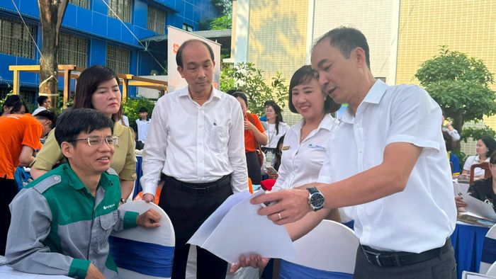 Phó Giám đốc Sở Nội vụ Hà Nội Nguyễn Tây Nam (giữa) cùng các đại biểu trao đổi tại các gian tư vấn của doanh nghiệp. Ảnh: Mai Hoa