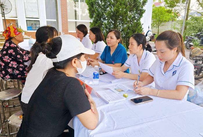 Người dân được hỗ trợ kê khai thông tin trước khi khám sức khỏe. Ảnh: Nguyễn Nga