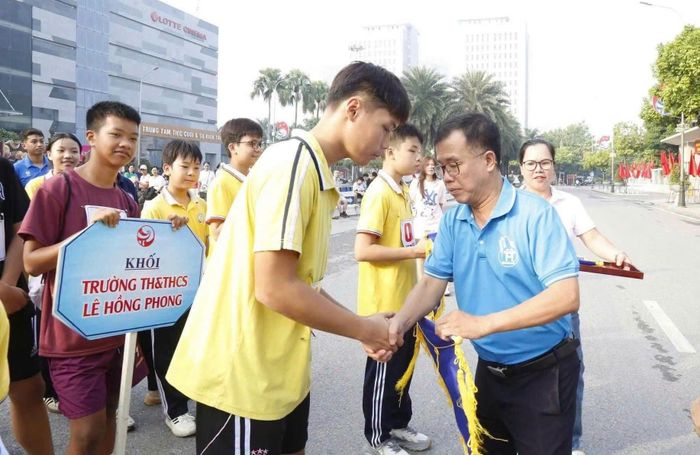 Đồng chí Lại Bá Hà, thành viên Hội đồng Biên tập cơ quan Báo và Phát thanh, Truyền hình Hà Nội trao cờ lưu niệm cho đơn vị tham gia. Ảnh: PV