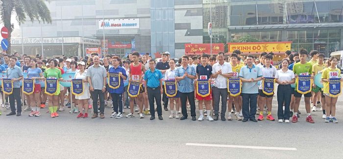 Thành viên Hội đồng Biên tập Cơ quan Báo và Phát thanh, truyền hình Hà Nội Lại Bá Hà cùng lãnh đạo phường Hà Đông và các đại biểu trao cờ lưu niệm cho các đơn vị tham gia giải chạy. Ảnh: PV