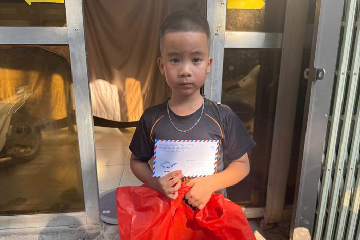 Em Lê Đức Huy, con của thành viên Hợp tác xã Người mù nhận phần quà Trung thu. Ảnh: Khánh Chi