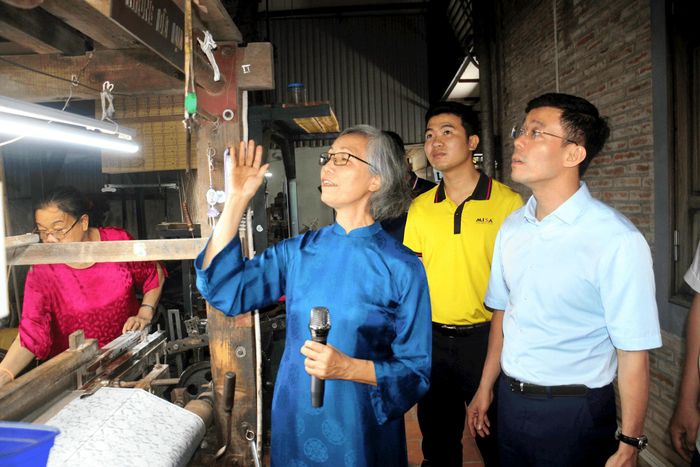Giám đốc Sở Khoa học và Công nghệ Hà Nội Cù Ngọc Trang nghe các nghệ nhân làng nghề Vạn Phúc giới thiệu về nghề dệt. Ảnh: Sở KHCN Hà Nội