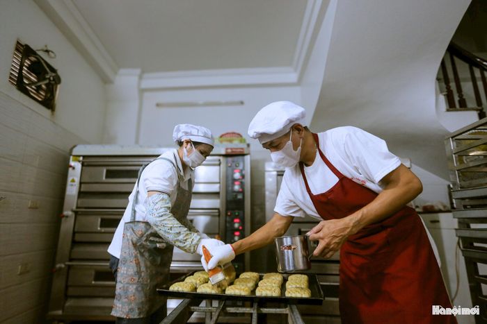 Từng viên nhân và vỏ bánh được đong đếm tỉ lệ chuẩn xác trước khi đưa vào khuôn gỗ đục hoa văn cổ truyền. Bàn tay khéo léo của thợ làng Nội Am dập từng nhịp dứt khoát, tạo nên những chiếc bánh nướng vàng ươm hay bánh dẻo trắng trong rực rỡ sắc màu mùa thu.