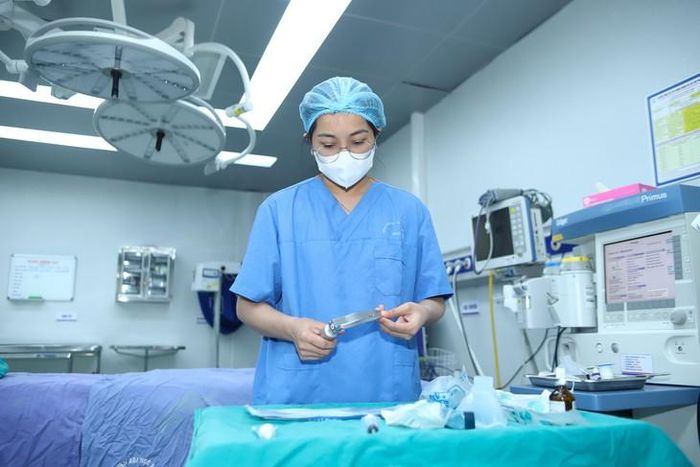 BSNT Lê Thị Thanh Trà kiểm tra dụng cụ chuyên dụng trước ca phẫu thuật tại Bệnh viện Đại học Y Hà Nội. Ảnh: Thành Long