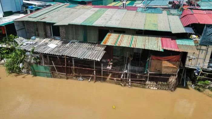 Vách tôn dựng sát mép. Cọc tuýp sắt hoen gỉ và lưới B40 cắm thẳng xuống bùn lầy để làm bệ đỡ cơi nới diện tích sinh hoạt, trực tiếp "bóp nghẹt" dòng sông.