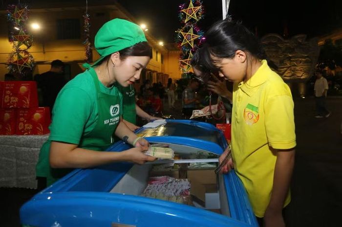 Các em nhỏ hào hứng dùng phiếu nhận quà do Ban Tổ chức phát để đổi lấy những que kem mát lạnh tại gian hàng
