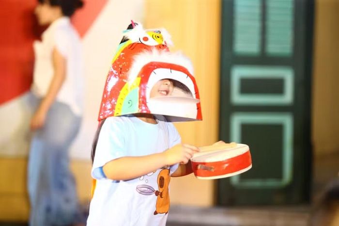 Em nhỏ thích thú ướm thử chiếc mặt nạ giấy bồi truyền thống, nụ cười rạng rỡ hiện rõ qua từng ánh mắt