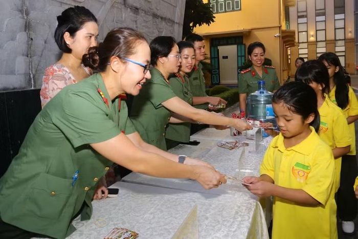 Nụ cười rạng rỡ của nữ chiến sĩ công an khi trao các phiếu quà Trung thu cho các em nhỏ đến từ Làng trẻ Birla