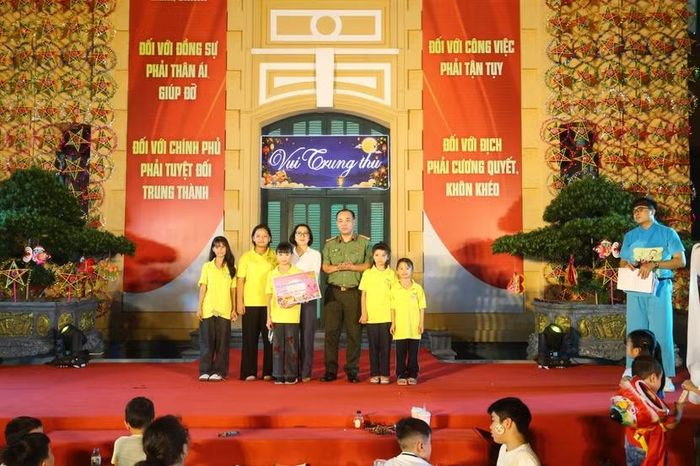 Thượng tá Lưu Hồng Quân - Phó trưởng Ban Biên tập Chuyên đề An ninh Thủ đô thay mặt Ban Tổ chức trao số tiền đấu giá tranh tặng đại diện Làng trẻ