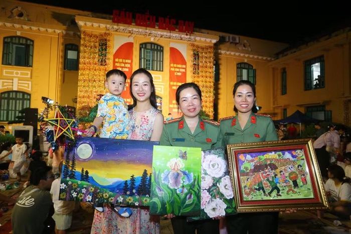 Cán bộ, chiến sĩ CATP Hà Nội vui mừng sở hữu bức tranh do chính các em nhỏ thể hiện, đóng góp toàn bộ kinh phí ủng hộ Làng trẻ Birla