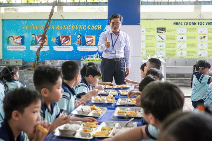 Hiệu trưởng trường Tiểu học Đinh Bộ Lĩnh (TP.HCM) kiểm tra bữa ăn bán trú của học sinh. Ảnh: Khương Nguyễn.