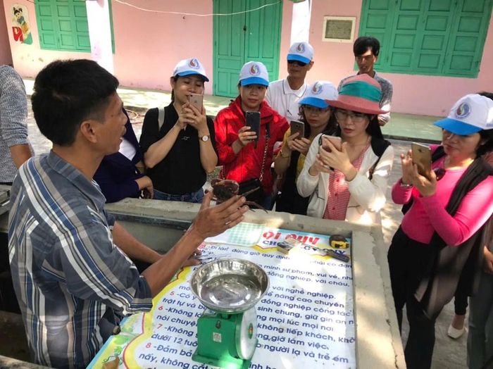 Du khách nghe giới thiệu về câu chuyện bảo tồn và khai thác văn minh cua đá Cù Lao Chàm