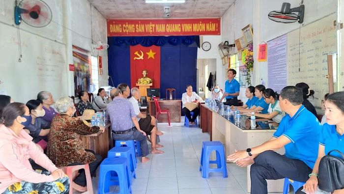 Bảo hiểm xã hội Cà Mau tuyên truyền chính sách mới tại cơ sở về tiện ích khi nhận thanh toán không dùng tiền mặt. (Ảnh: THÀNH ĐẠT)