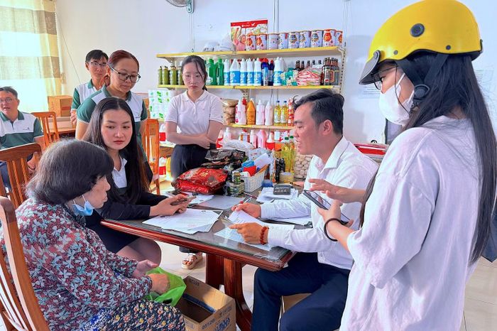 Cán bộ Bảo hiểm xã hội Cà Mau phối hợp cùng các đơn vị liên quan đến tận nhà hỗ trợ làm thủ tục mở thẻ cho cán bộ hưu trí. (Ảnh: THÀNH ĐẠT)
