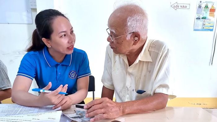 Cán bộ Bảo hiểm xã hội Cà Mau tuyên truyền, giải thích cho cán bộ hưu trí về những lợi ích khi nhận lương hưu và trợ cấp Bảo hiểm xã hội hằng tháng qua tài khoản ngân hàng. (Ảnh: THÀNH ĐẠT)