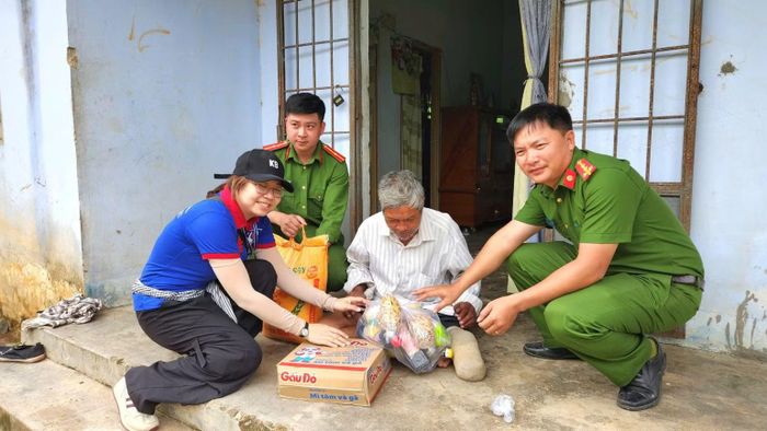 Các lực lượng tặng quà cho người dân. (Ảnh: QUÝ NGỌC)