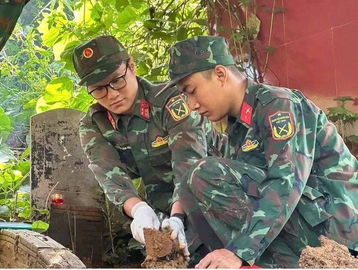 Cán bộ, chiến sĩ Bộ Chỉ huy Quân sự tỉnh Điện Biên cẩn trọng tìm kiếm mẫu trong từng phần mộ liệt sĩ. (Ảnh: LÊ LAN)