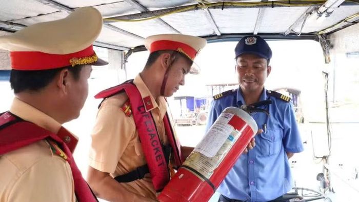 Kiểm tra hạn sử dụng và tình trạng hoạt động của bình chữa cháy trang bị trên tàu du lịch. (Ảnh: Công an cung cấp)